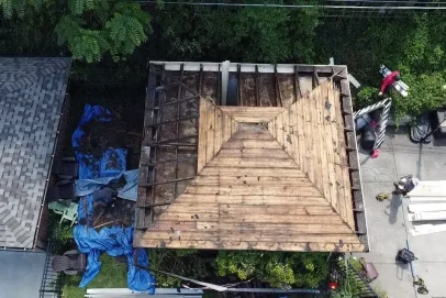 Roof renovation with exposed wooden structure.